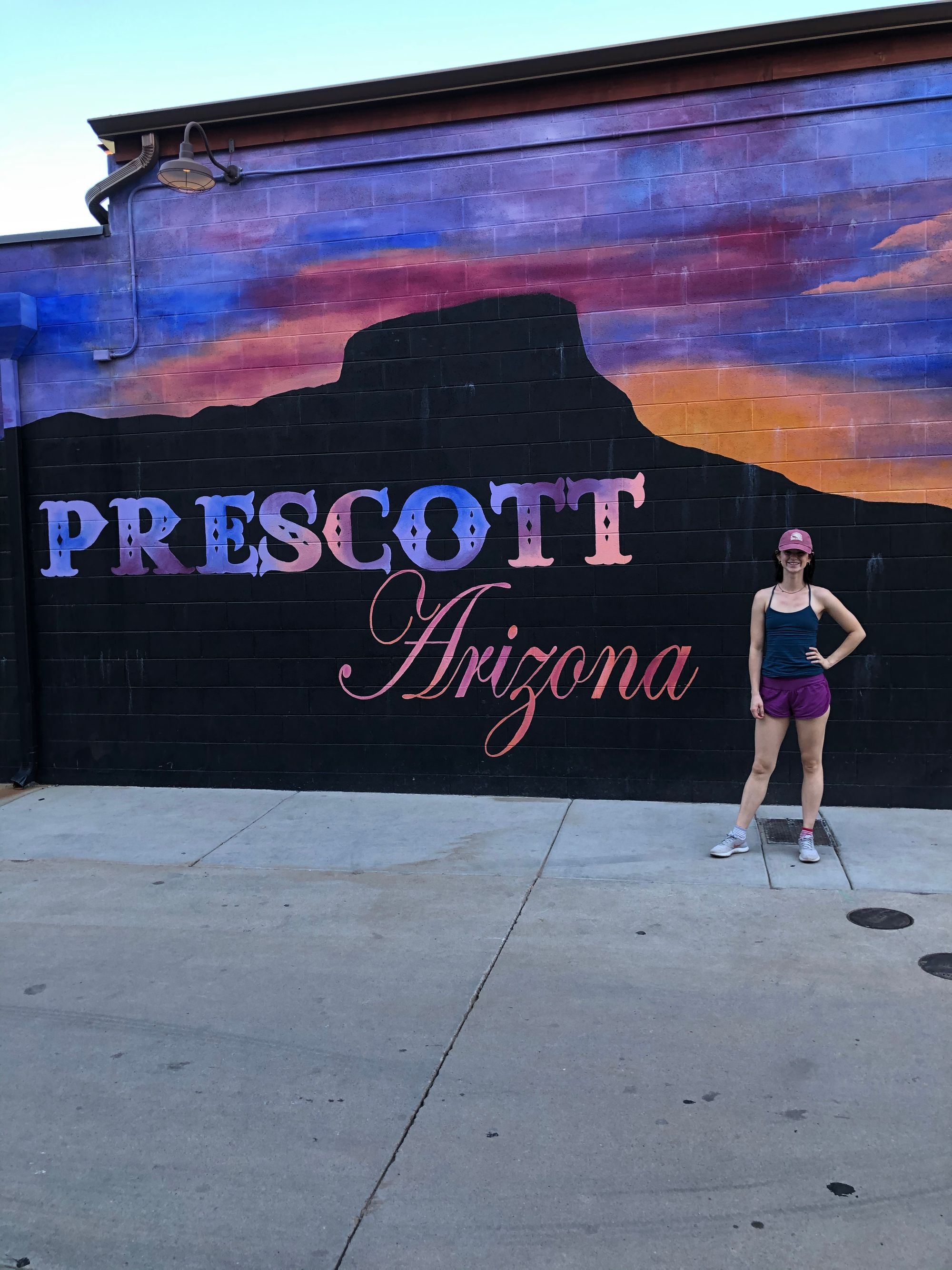 lacy standing in front of the Prescott mural at Whiskey Row in Prescott, Arizona