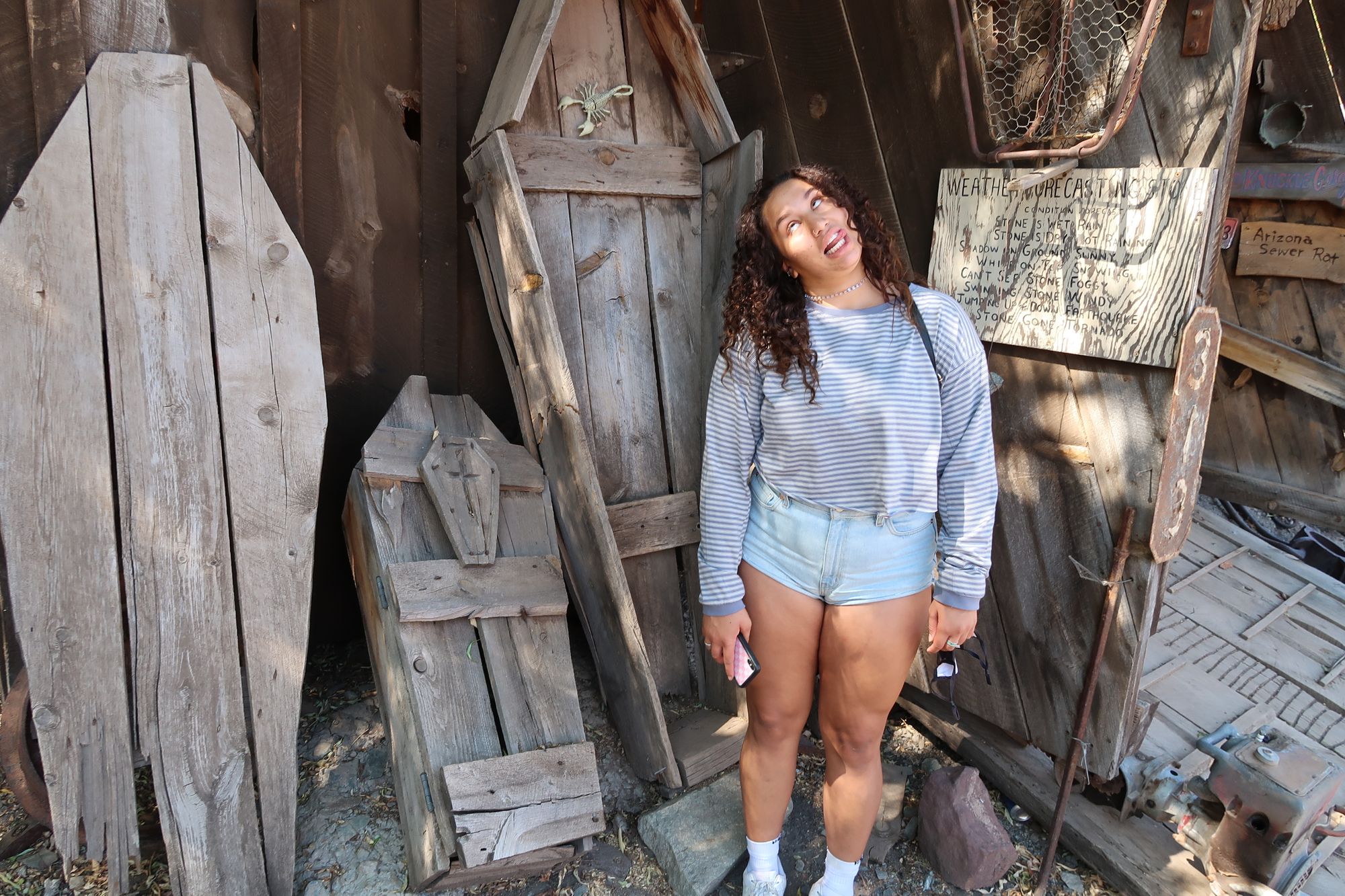 Girl posing with coffins at Ghost Town in Jerome, AZ