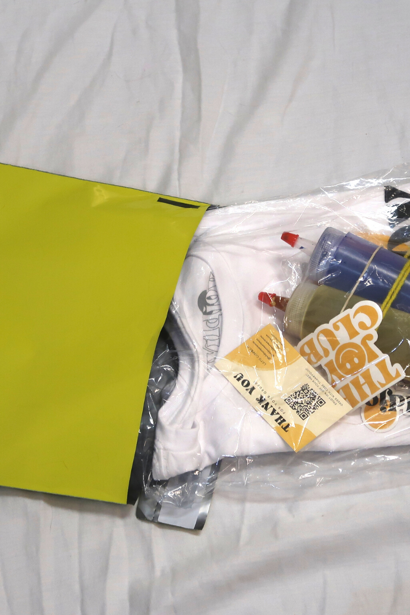 Yellow bag, plastic bag, tie-dye materials, thank you card, and bottles of dye