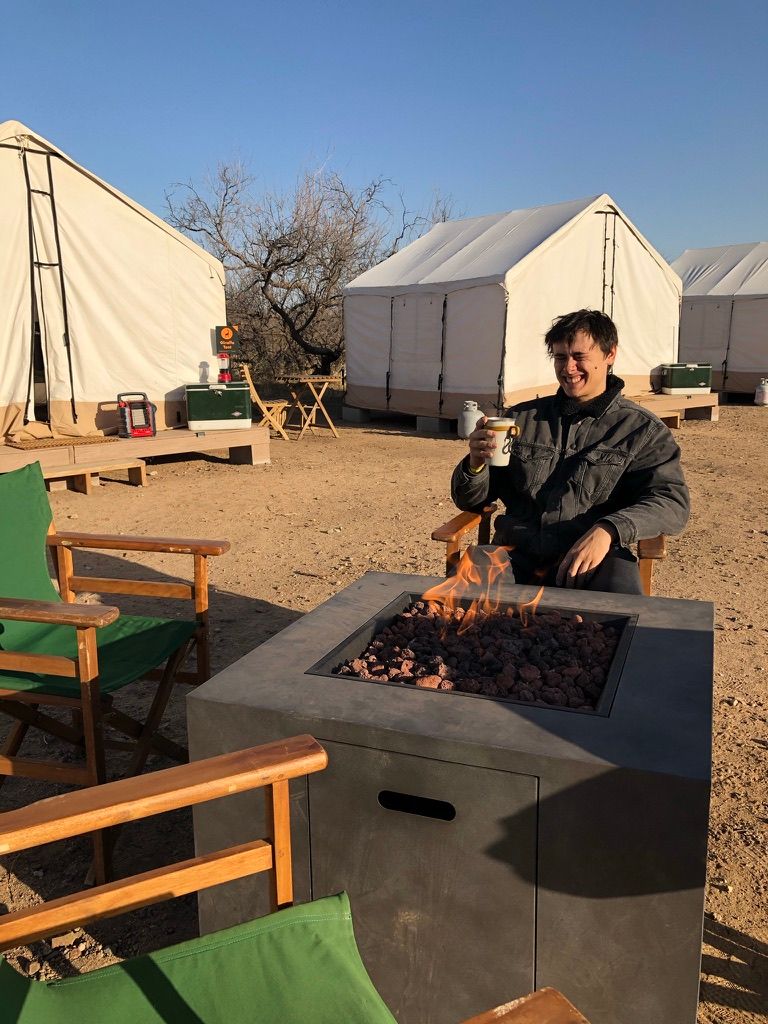 Man sitting at firepit glamping at Out of Africa in Arizona