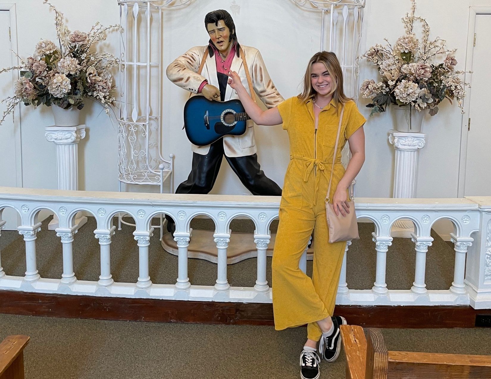 A girl posing next to a statue of Elvis Presly at the Elvis Memorial Chapel at the Superstition Mountain Museum