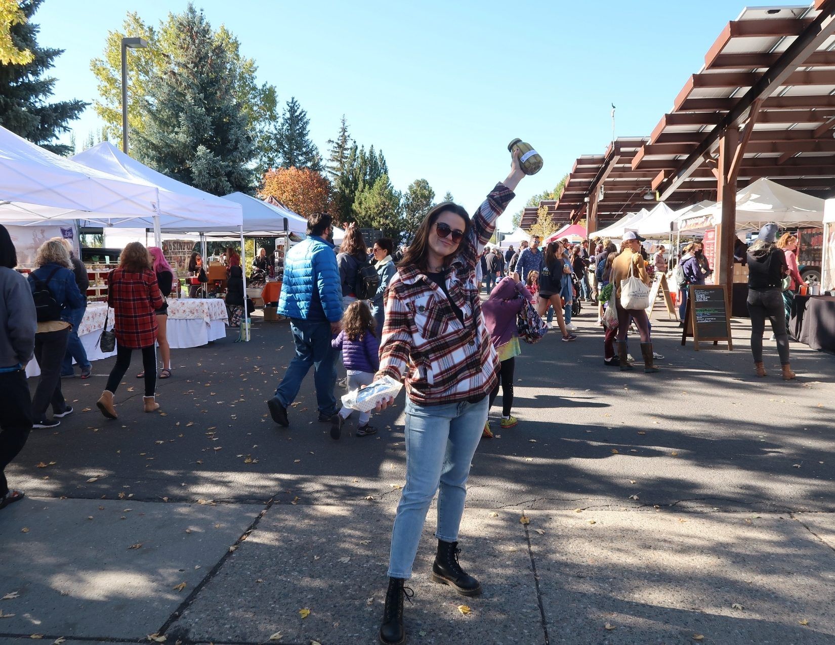 Lacy posing with local products in front of the vendors at the Flagstaff Community Farmer's Market in Arizona.