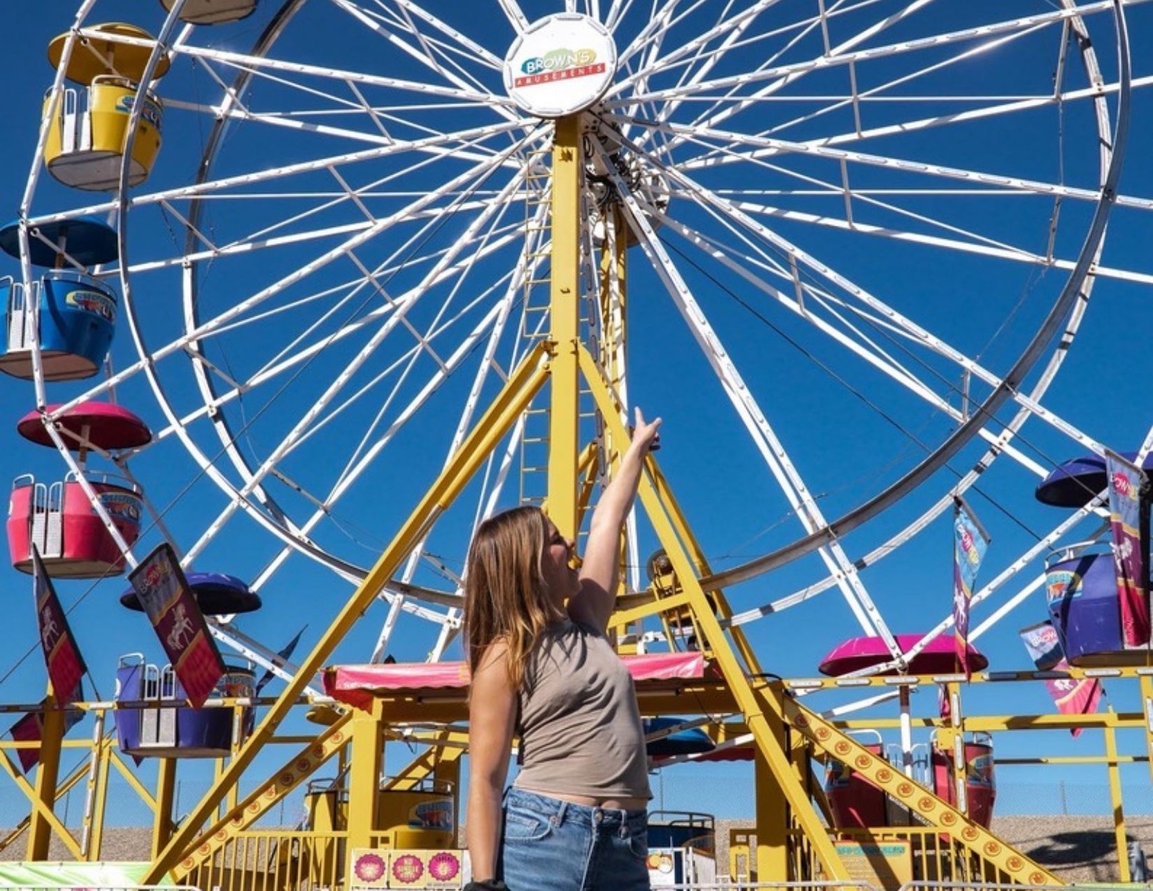 Lacy Cain pointing to the ferris wheel at the carnival for Gold Rush in Wickenburg, Arizona