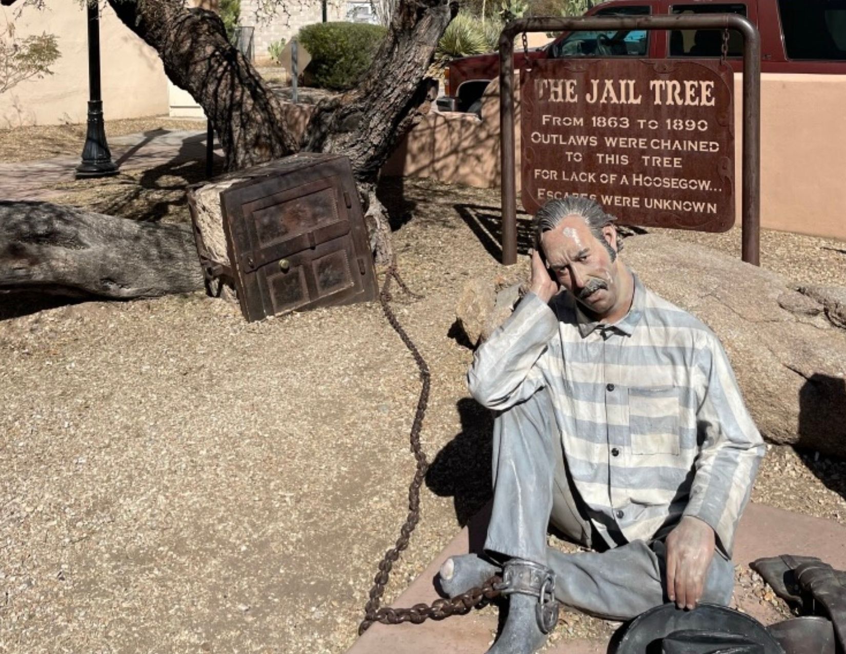 a statue of a man chained to the Jail Tree in Wickenburg, Arizona