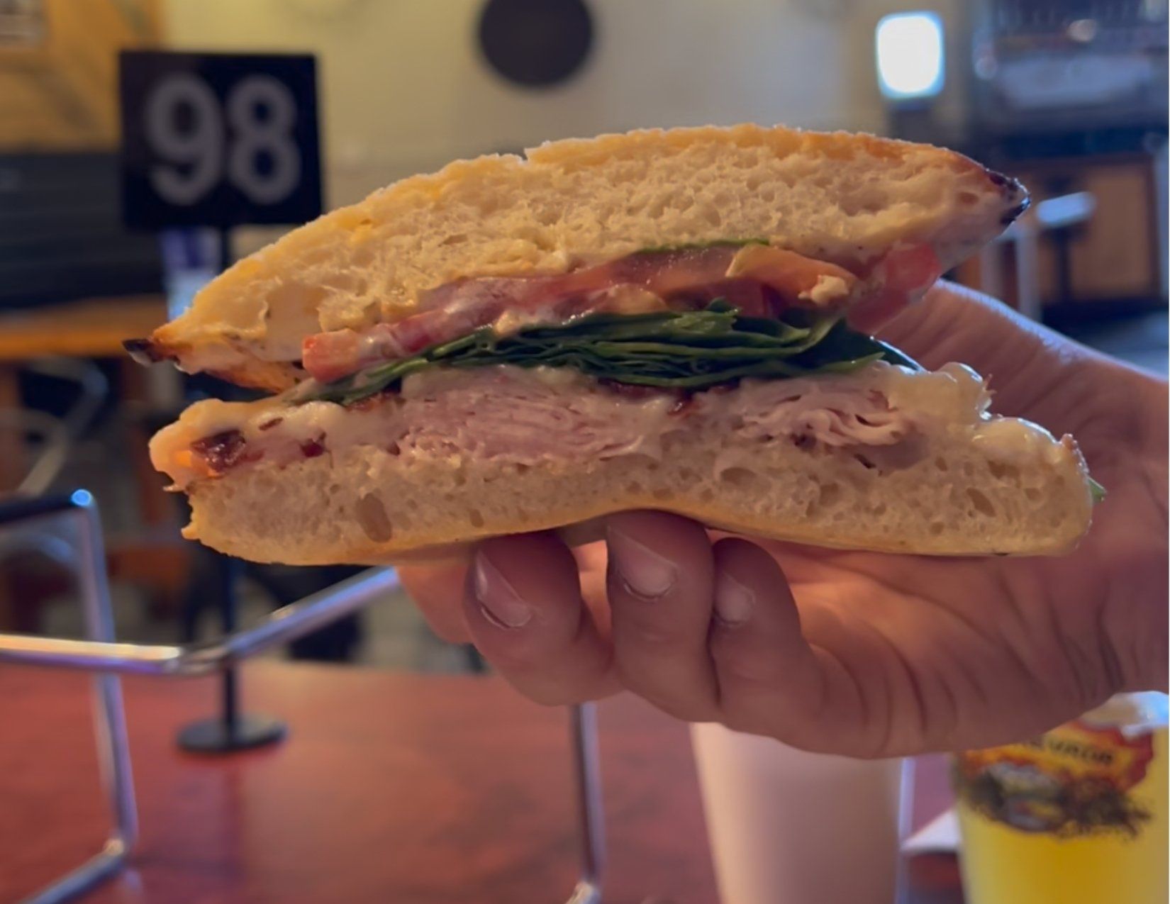 Hand holding fresh cut sandwich at Floyd and Company in Kingman Arizona