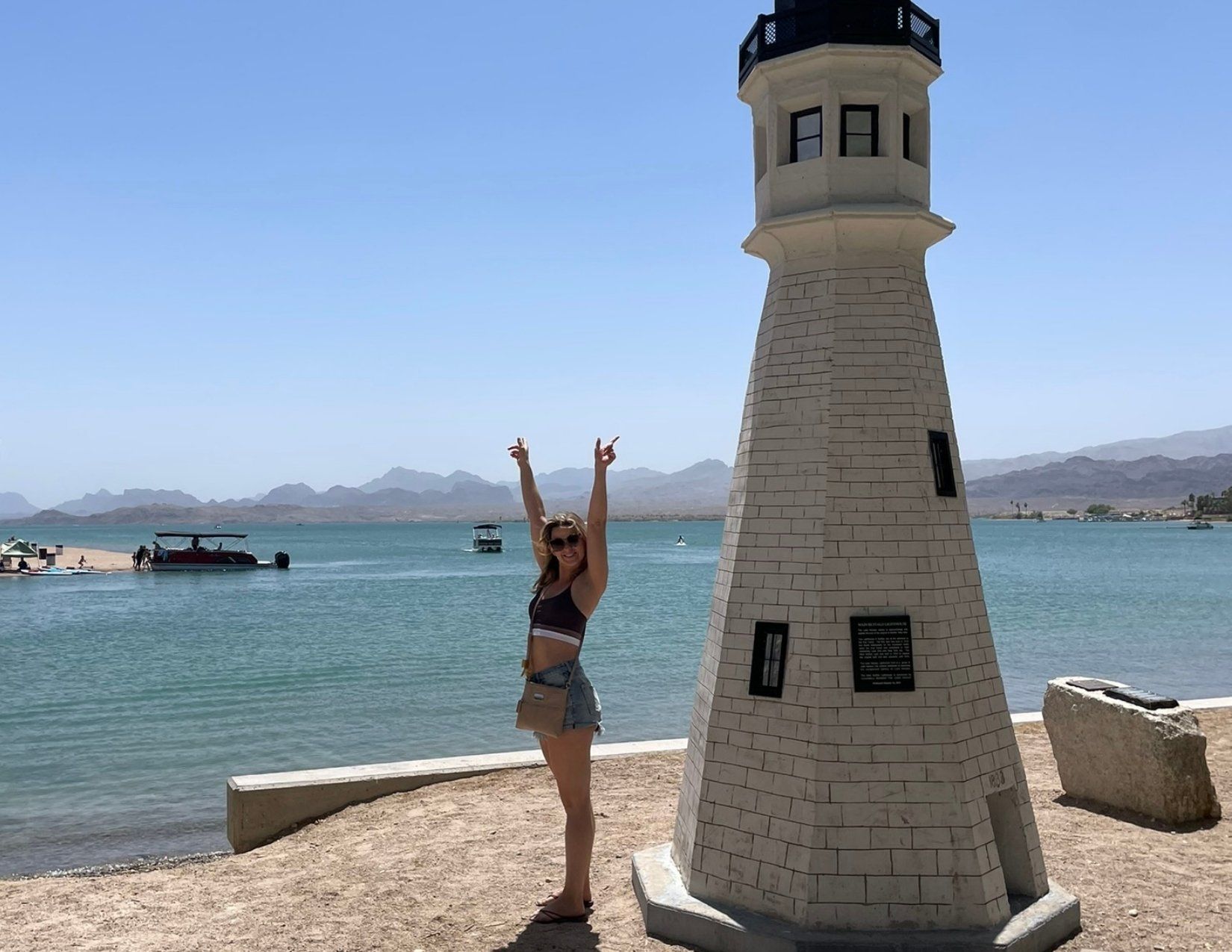 a girl posing in front of a miniature lighthouse at London Bridge Beach in Lake Havasu City