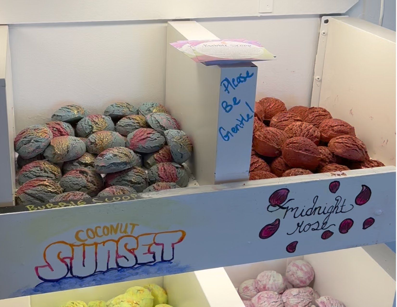 Coconut Sunset and Midnight Rose bath bombs on display at Savon Bath Treats in Kingman Arizona