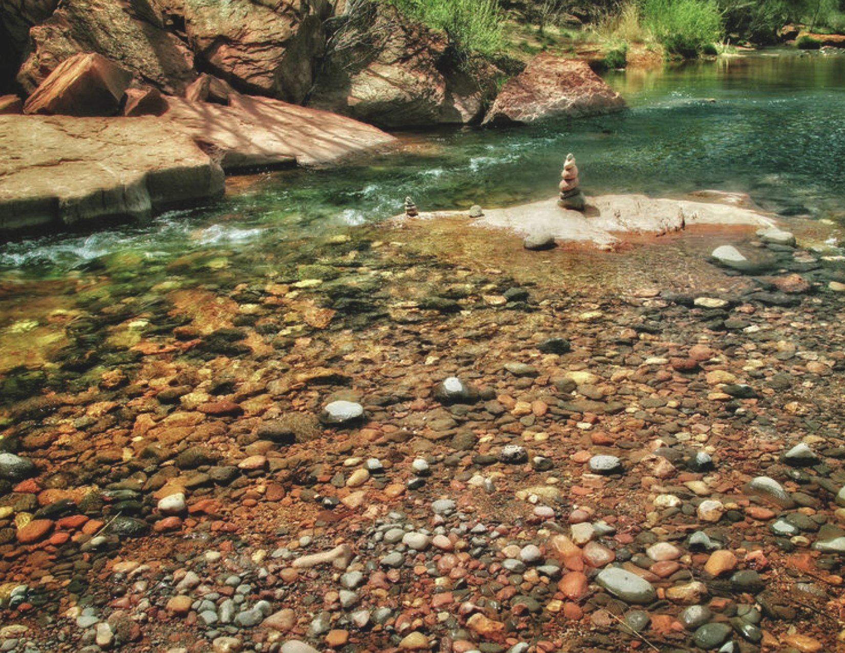 Colorful Rocks by the clear blue water at Buddha Beach in Sedona Arizona