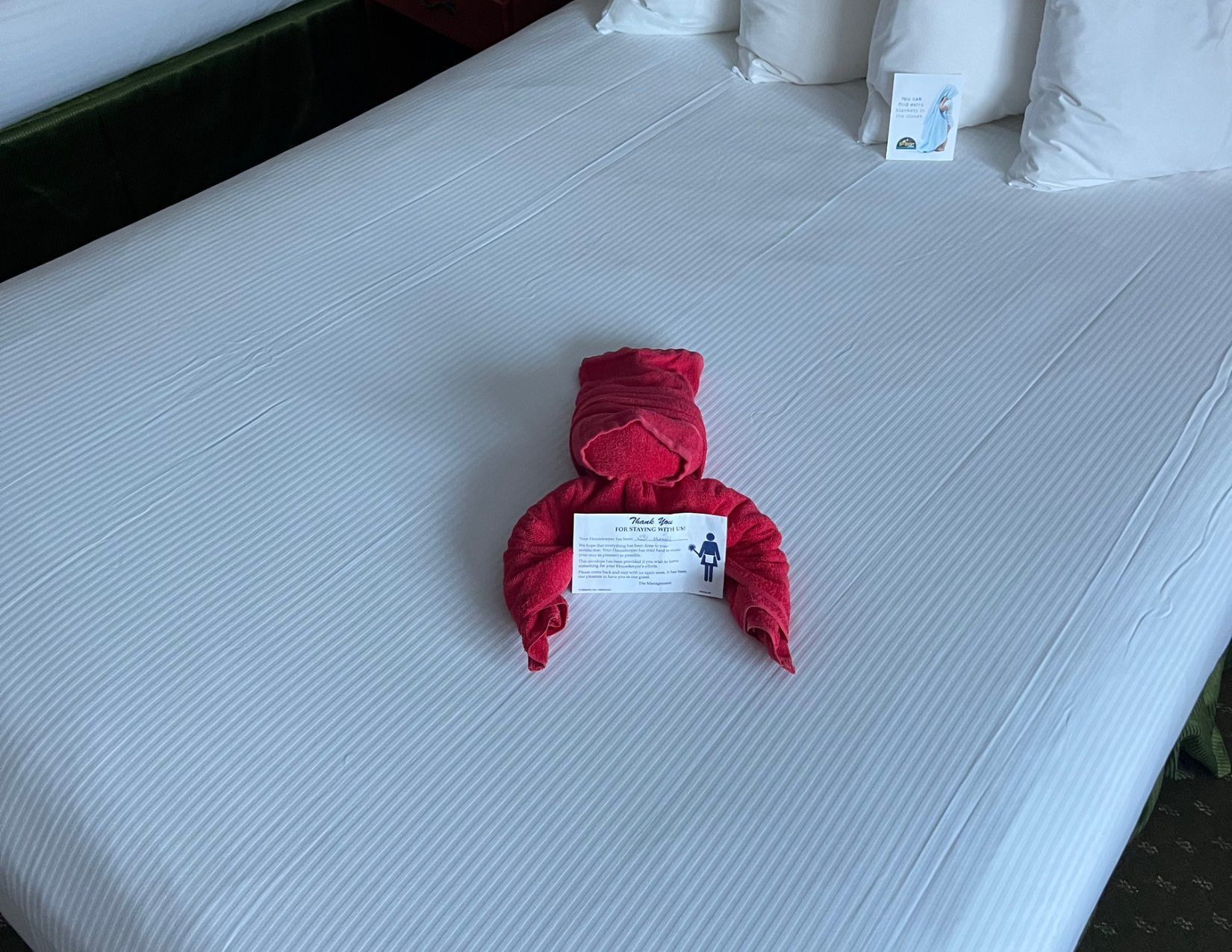 A red towel folded to look like a lobster, displayed on a bed in a motel in Bar Harbor, Maine