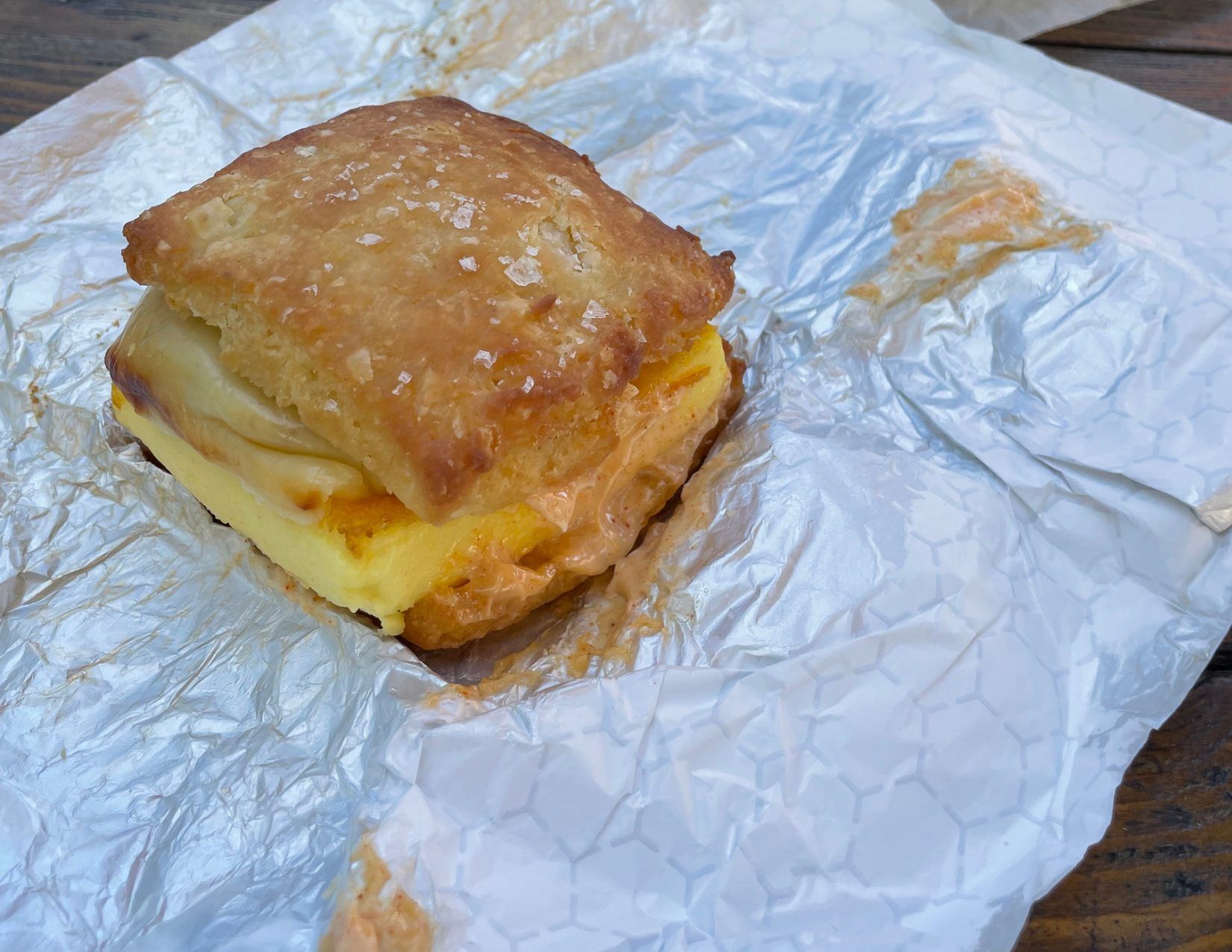 A perfectly flakey biscuit with egg, cheese, and chorizo, wrapped in foil, for breakfast in Portland, Maine