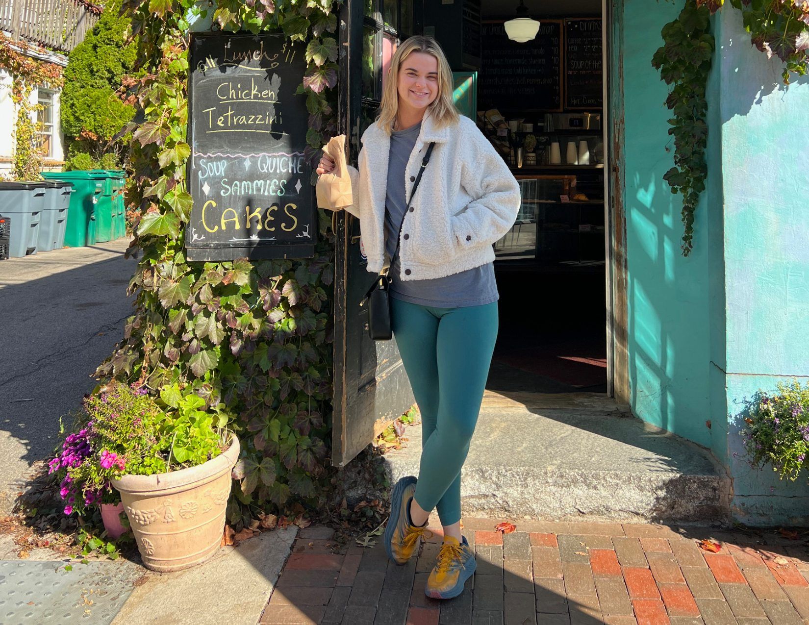 Lacy Cain Baranack smiling with her pastries outside of a cute and cottage style family owned bakery in Portsmouth, NH.