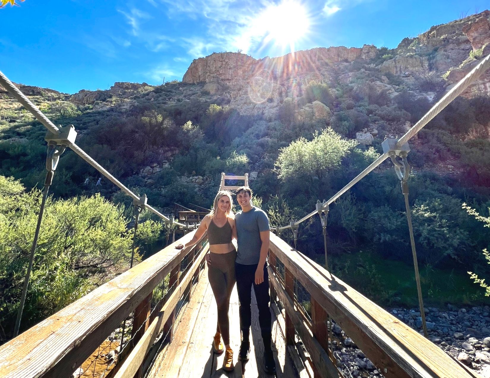 man and woman standing next to each other on wooden bridge at Boyce Thompson Arboretum in Superior Arizona
