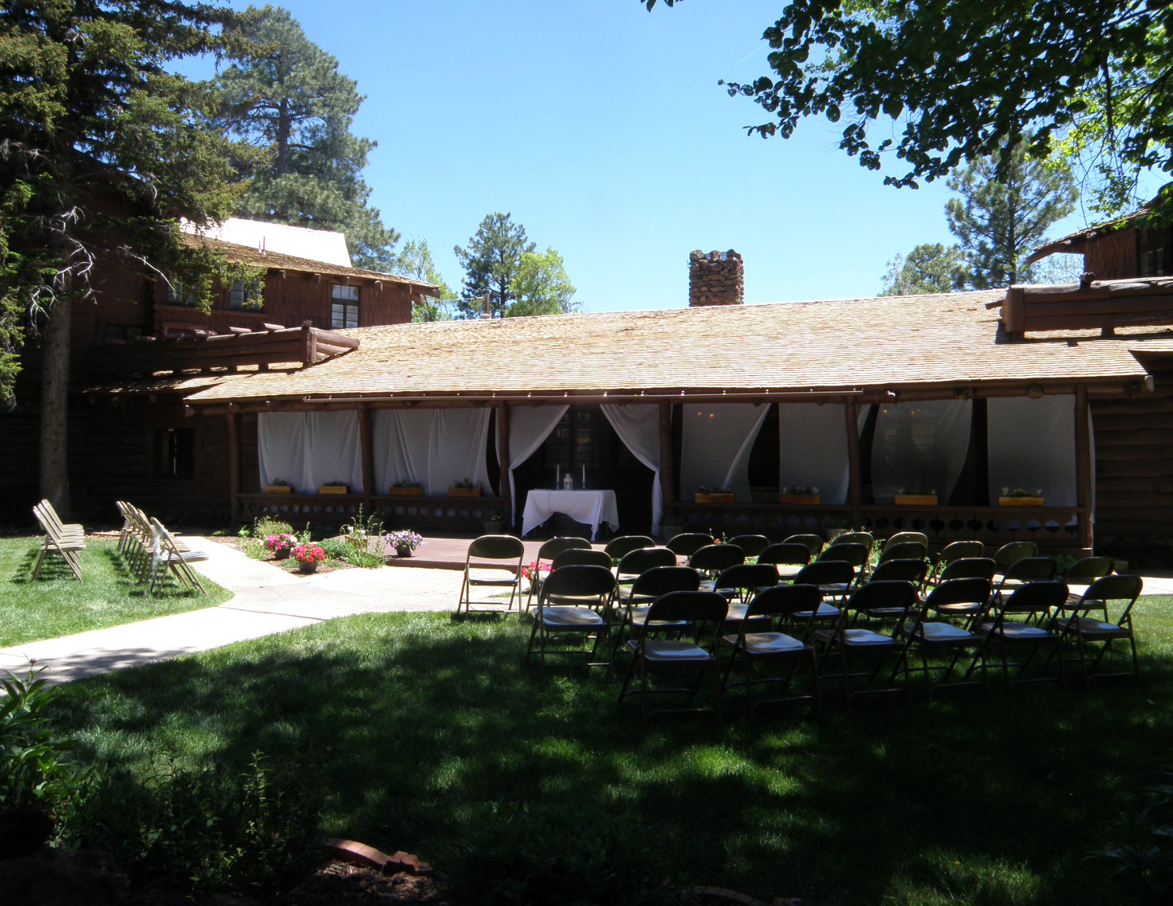 A rustic wedding ceremony at Riordan Mansion State Historic Park surrounded by tall trees in Flagstaff, Arizona