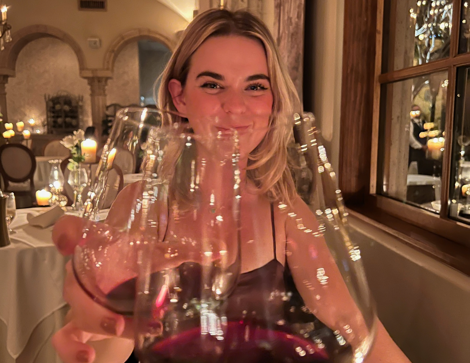 Woman holding up a glass of red wine during dinner at Cafe Monarch in Scottsdale, Arizona