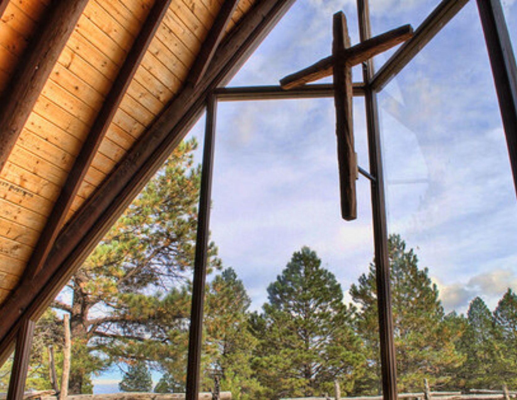 The view of ponderosa pines and aspens from large windows inside a small wedding chapel in Flagstaff, Arizona