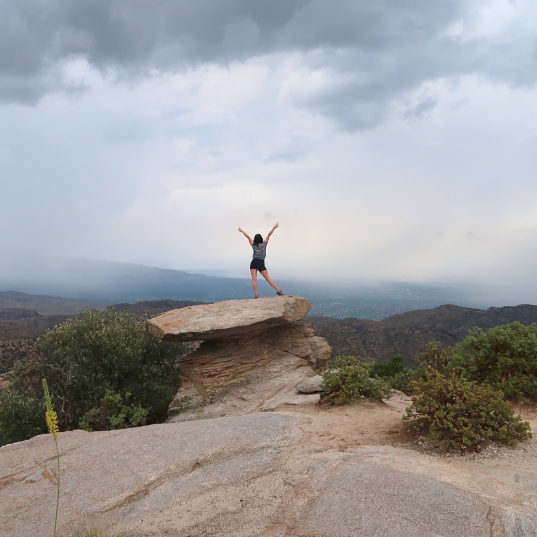 Woman posing on top of cool rock at Windy Point Vista on Mount Lemmon in Arizona