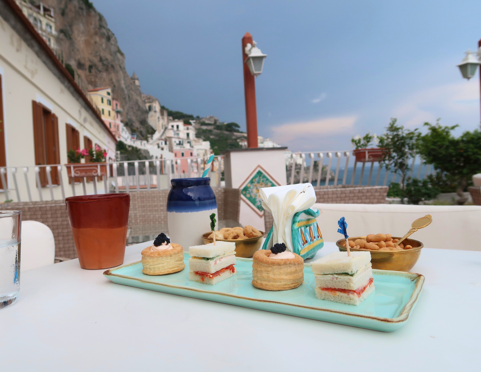 A mint green rectangular plate with elegant appetizers at a rooftop bar in Amalfi, SA, Italy