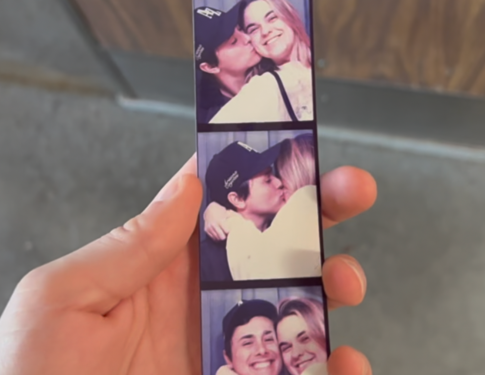 Hand holding a strip of three photos of a couple hugging and kissing, from a vintage photo booth in Gilbert, Arizona 