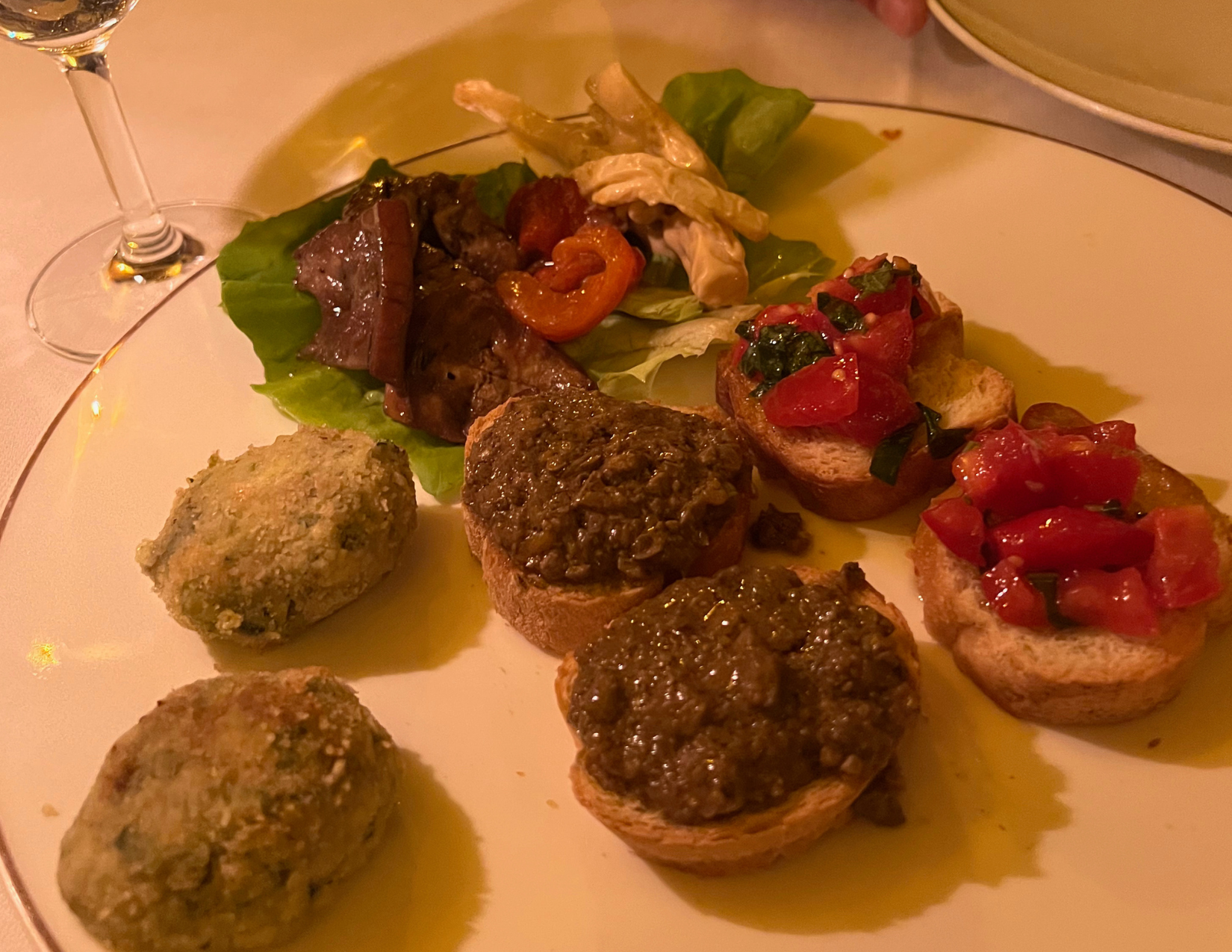 plate of food with tomatoes, beef pate and spinach cakes at La Giostra in Florence, Italy