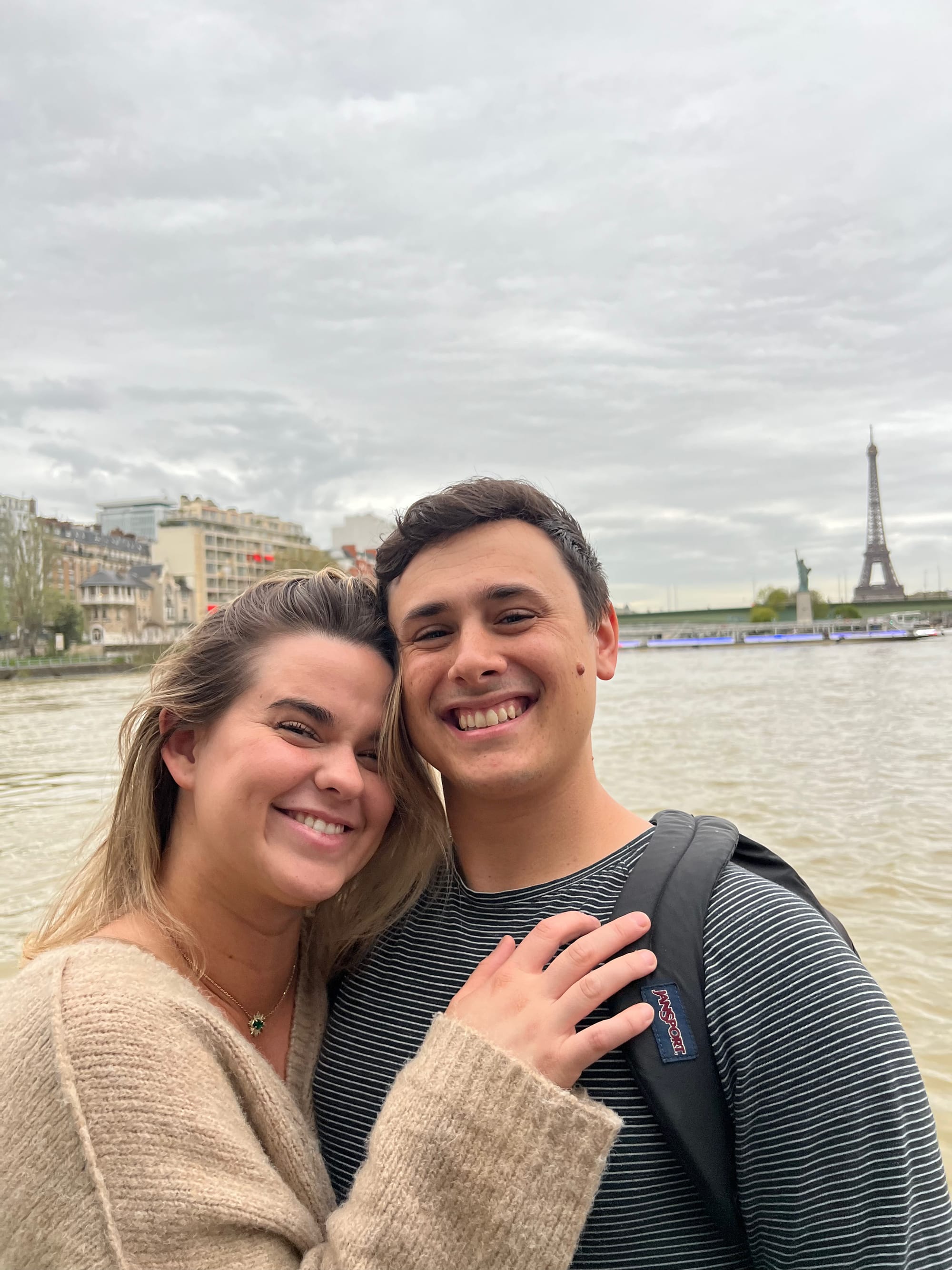 Man and woman on a Siene river boat cruise with the Eiffel Rower in the background in Paris, France