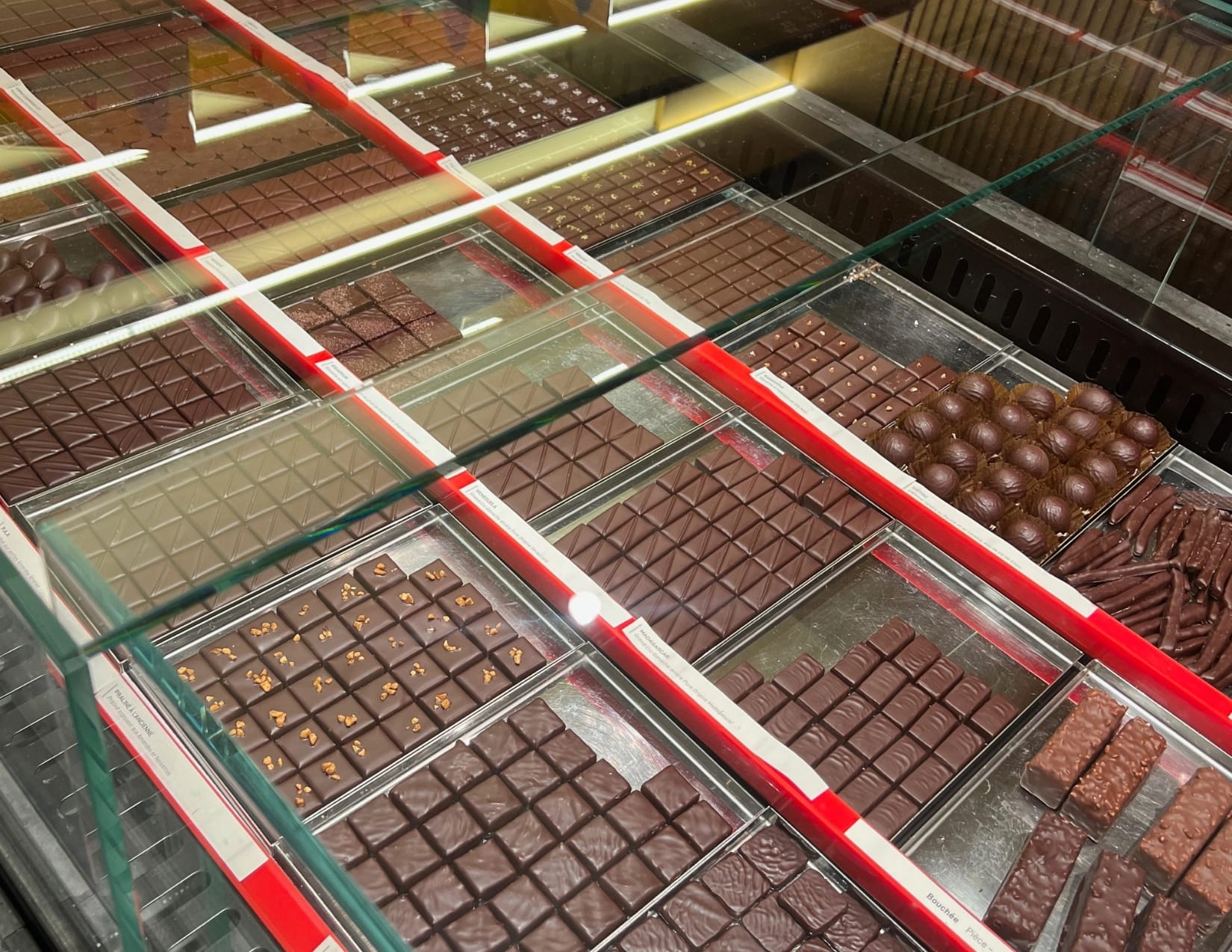 Rows of chocolate in a glass container at Maison le Roux in Paris, France