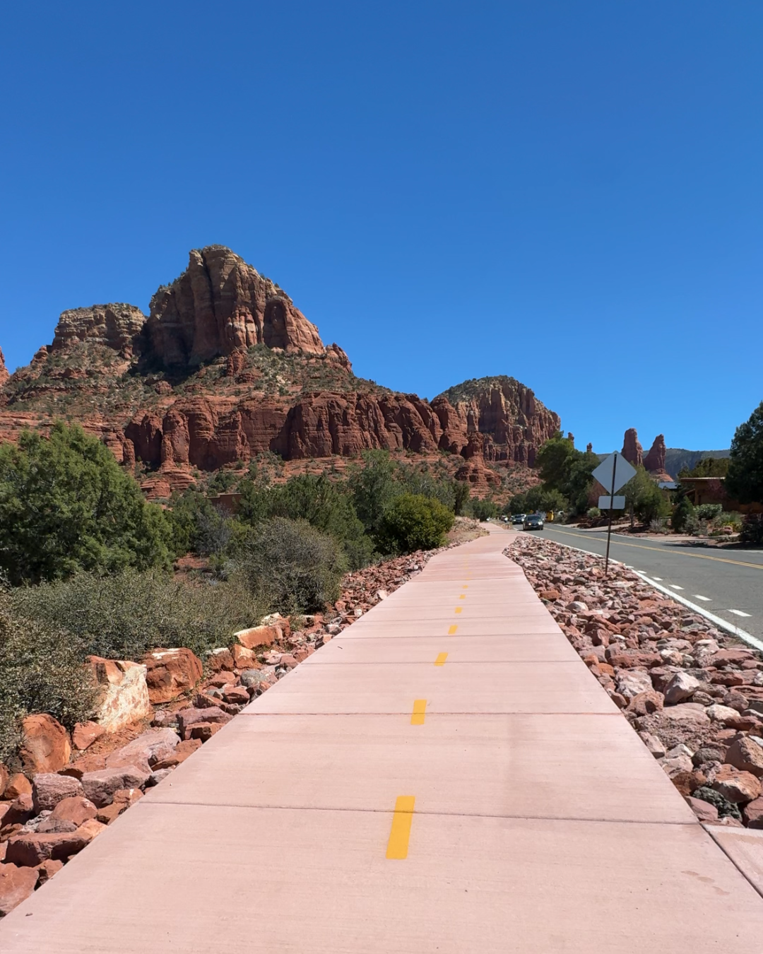bike trail with massive red rock behind with great views
